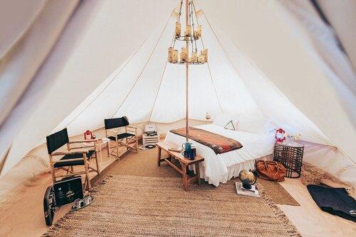 inside of a bell tent with furniture and beds
