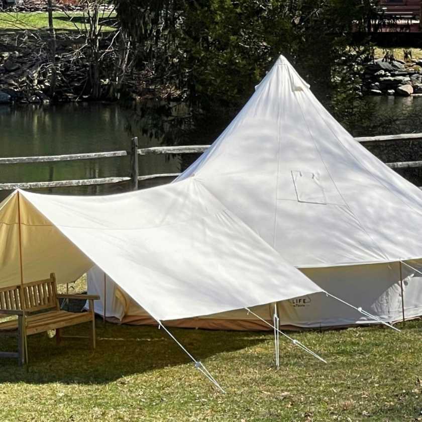 canvas camping tent with a awning attached to it