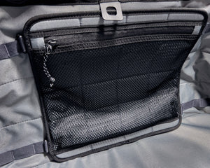 Close-up of a black zippered pouch on a gray fabric background