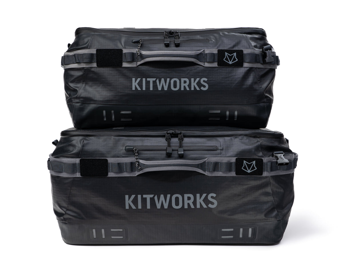 Two black Kitworks waterproof luggage bags stacked vertically on a clean white background.
