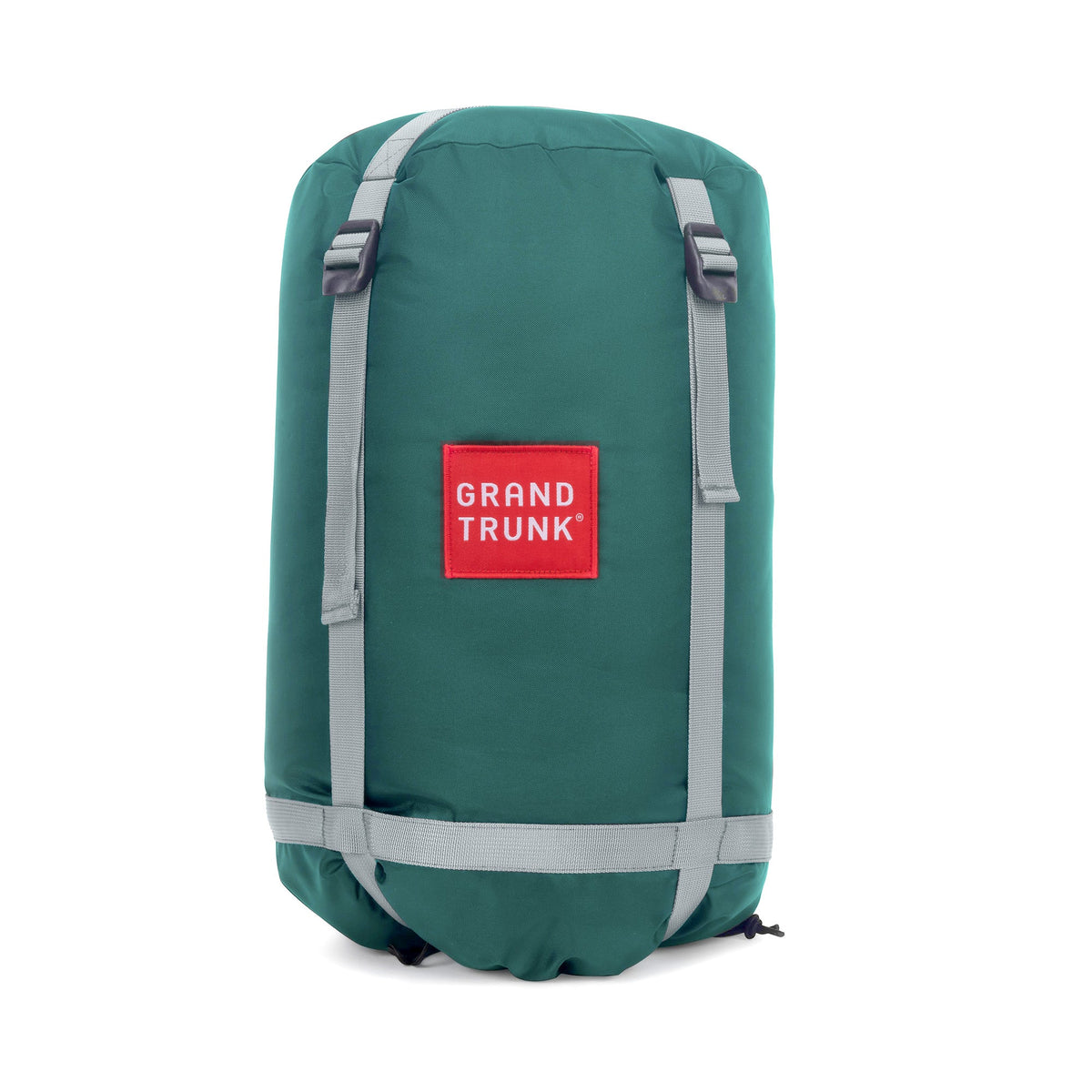 Green sleeping bag compression bag with 'Grand Trunk' logo on a white background