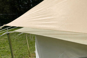 champagne tarp stretched over a camping setup with grass and trees in the background