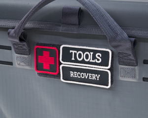 Gray box with 'Tools' and 'Recovery' patches on a dark background