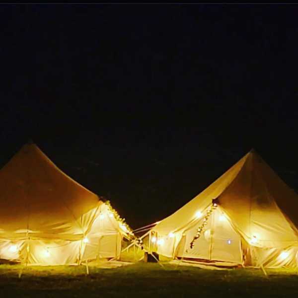 bell tents at night lit up