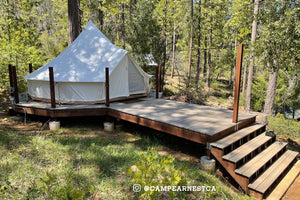 bell tent on a wood deck in the woods