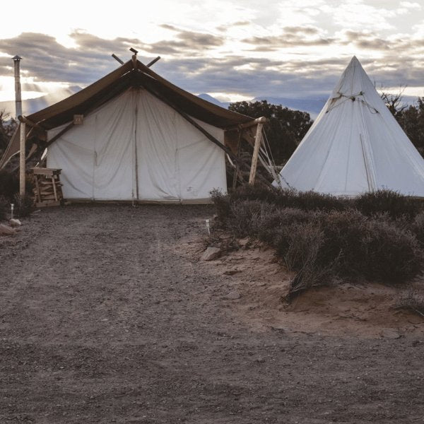 canvas safari wall tent and canvas teepee tent at sunset