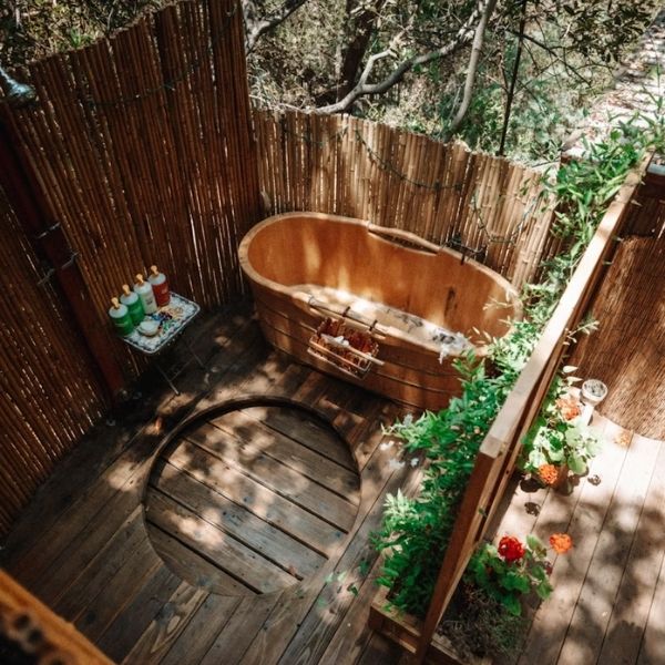 outdoor wood tub behind privacy screen in forest