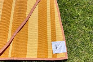 logo on striped bell tent rugs on grass