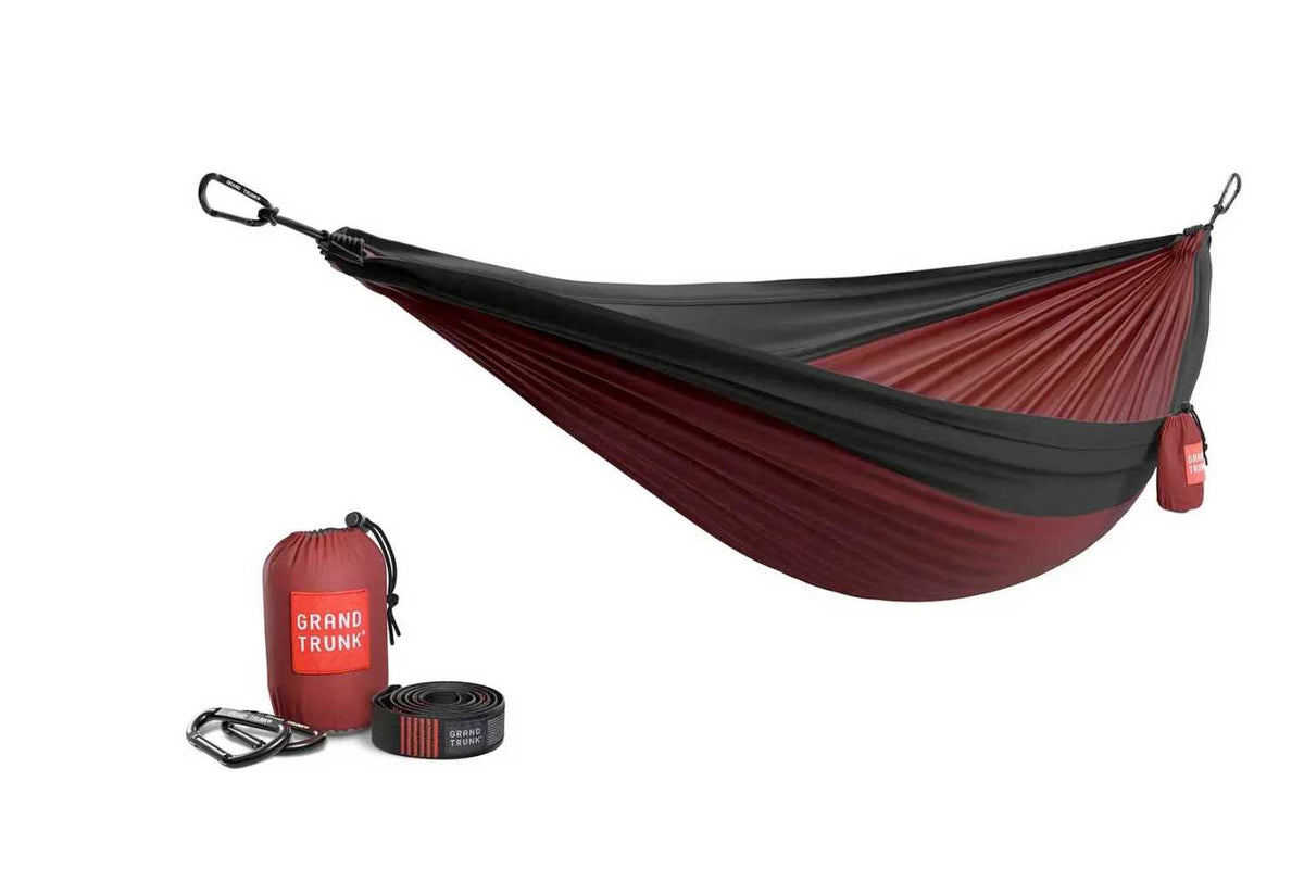 Red and black hammock with carrying bag and straps on a white background