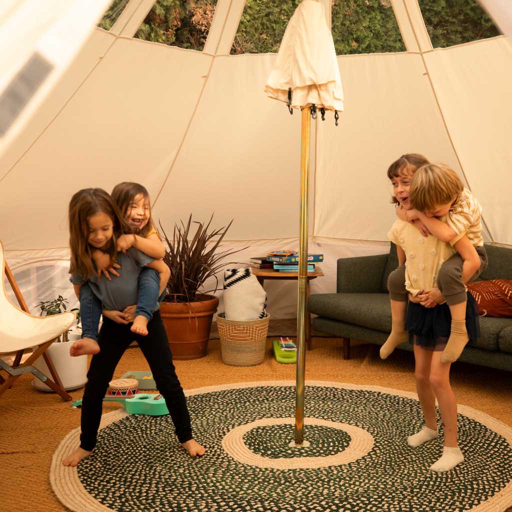 Children inside of large tent giving piggy back rides