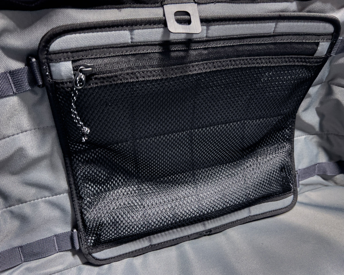 Close-up of a black zippered pouch on a gray fabric background