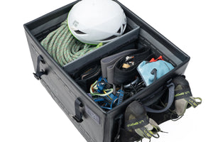 Storage compartment with climbing gear including a helmet, ropes, and harnesses on a white background