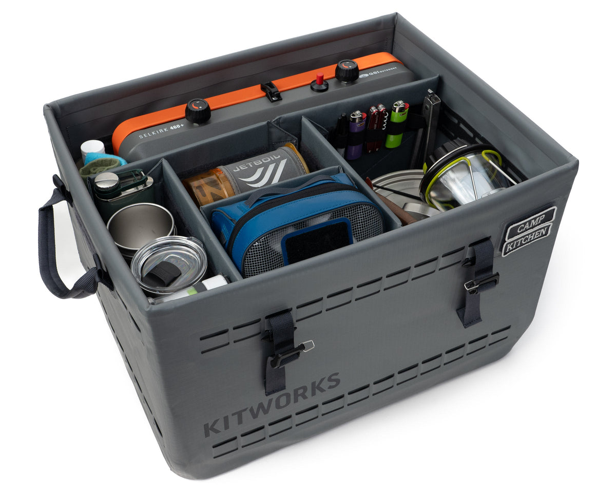 Gray camping storage box with various camping items inside, branded 'Kitworks'.