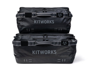 Two black Kitworks waterproof luggage bags stacked vertically on a clean white background.