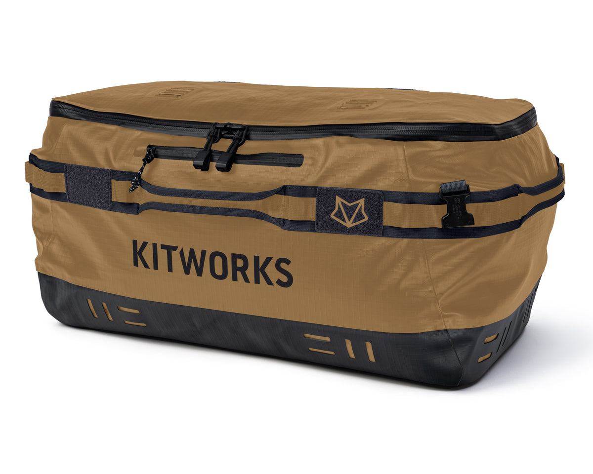 A Kitworks waterproof duffel bag in tan and black, featuring multiple zippered compartments, compression straps, and the Kitworks logo printed on the front, set against a plain white background.