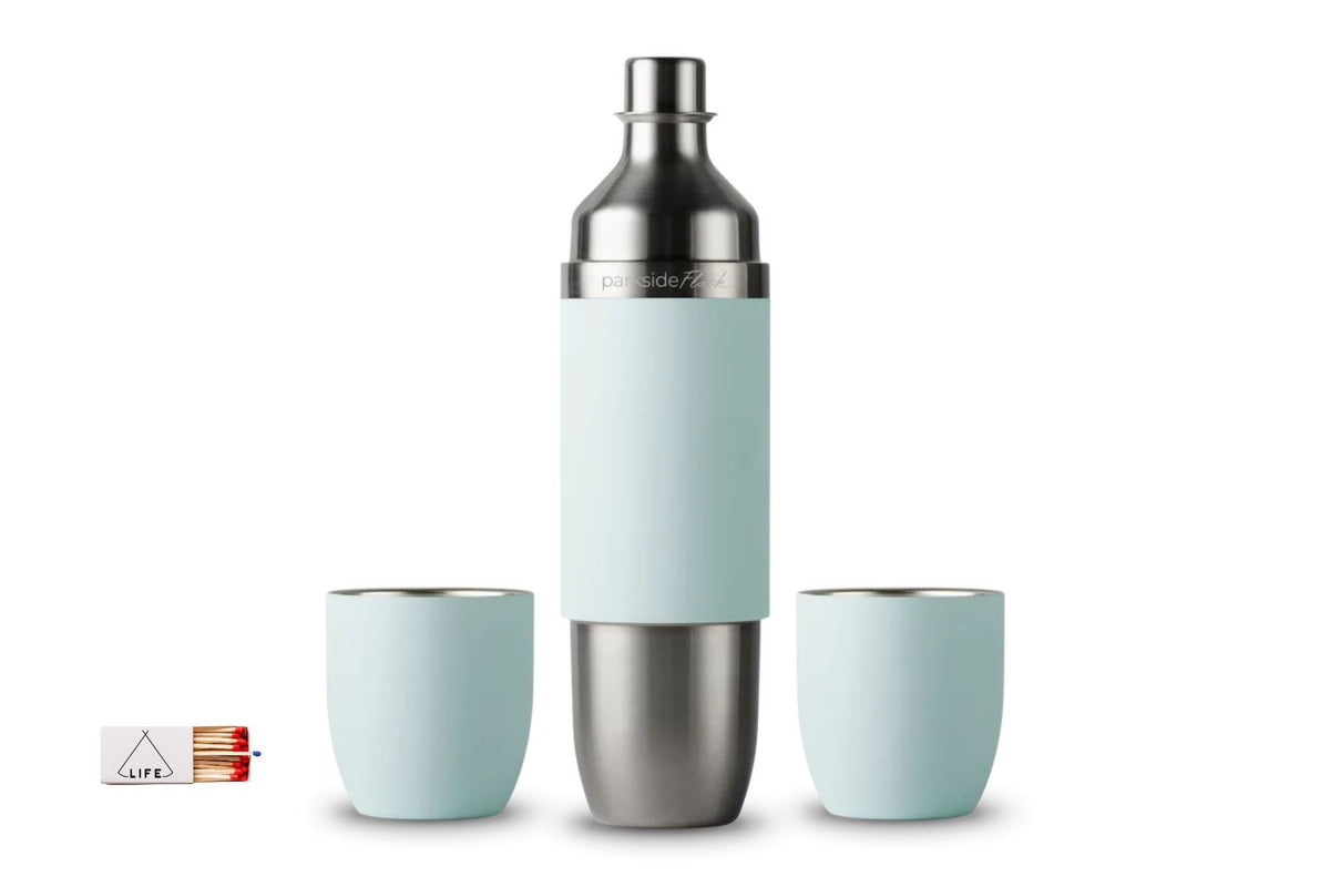A stainless steel parkside wine flask with a pale mint green silicone outside, flanked by two matching pale mint green tumblers, on a white background. A small matchbox with a 'LIFE' logo is visible in the bottom-left corner.