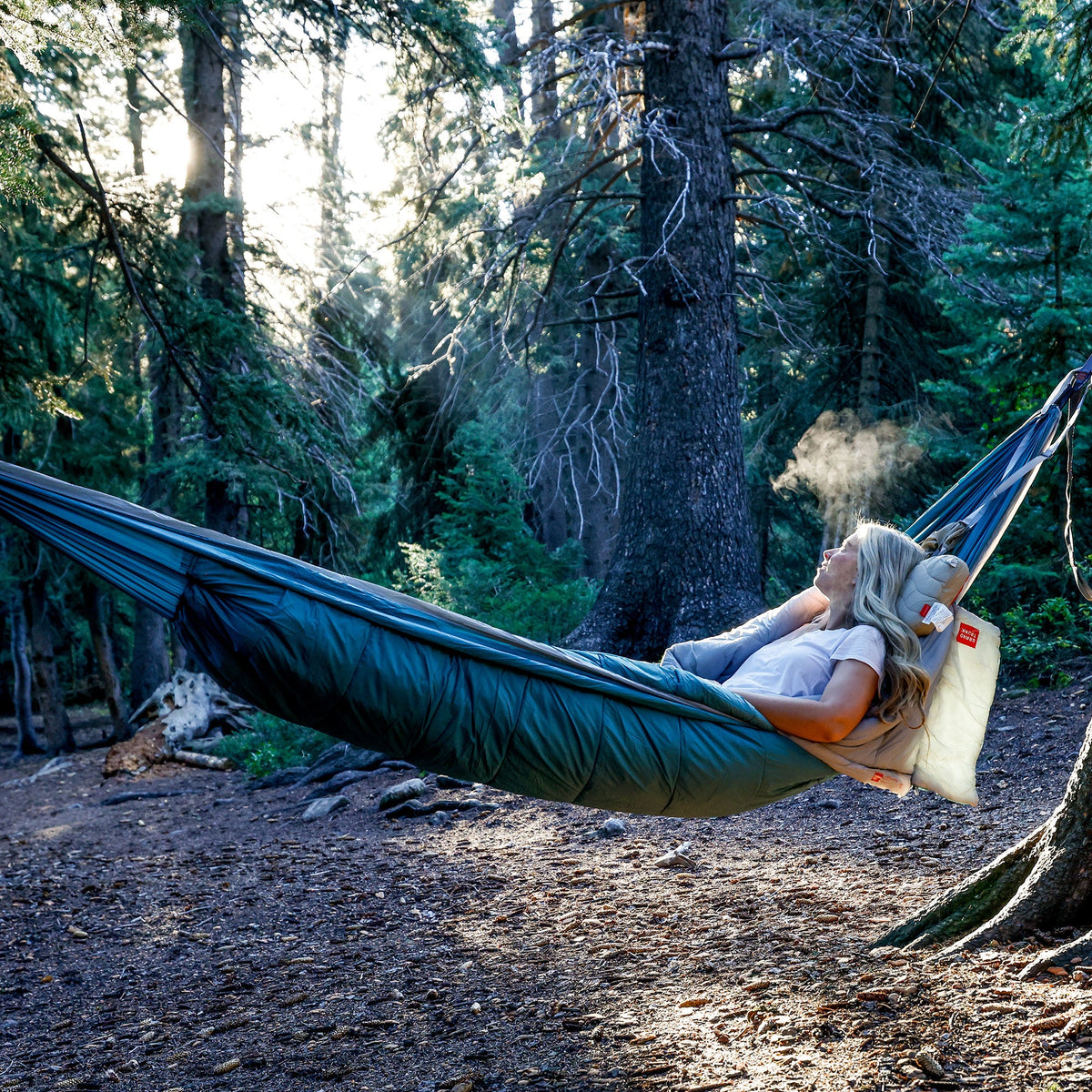 Person relaxing in a hammock in a forest setting