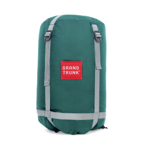 Green sleeping bag compression bag with 'Grand Trunk' logo on a white background