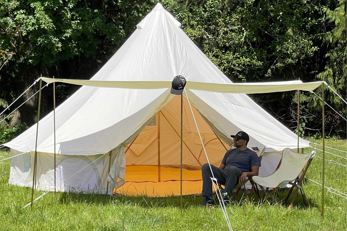 man sitting in front of tent in shade