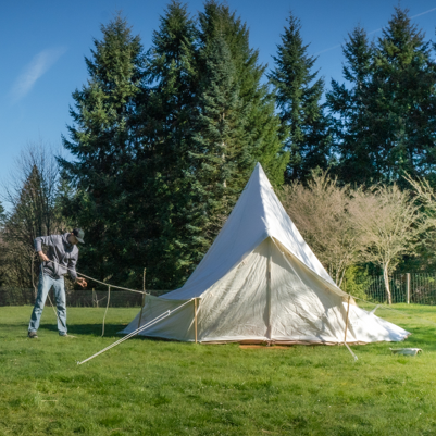 person setting up bell tent