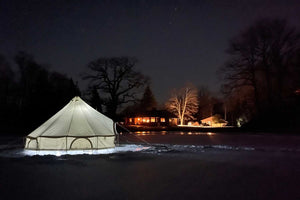 bell tent on a lake at night in winter