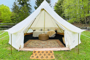 bell tent furnished with rugs and bed