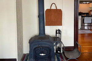 suede log carrier hanging near wood stove