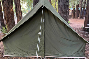 front of green aframe tent