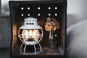winter camping lantern in wood box near flowers