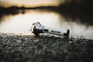 white camping flashlight at lake